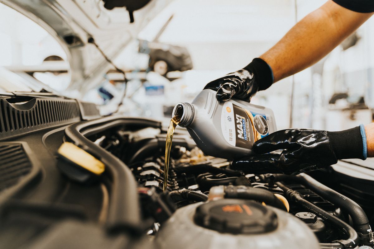 Pouring motor oil into a car engine